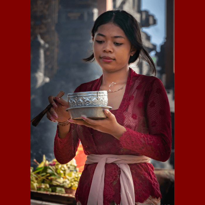 Femme avec tenue traditionnelle qui fait une offrande quotidienne